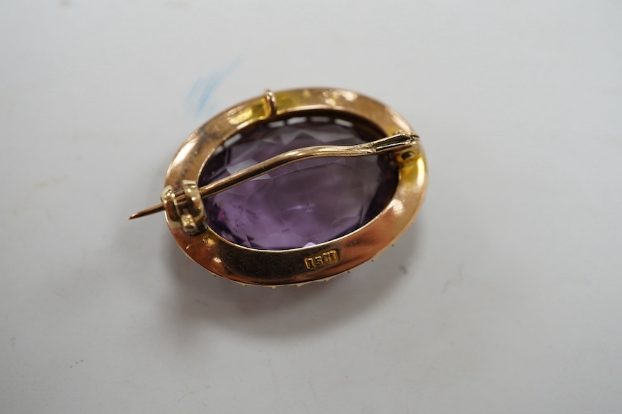 An Edwardian 15ct, amethyst and split pearl cluster set oval brooch, 23mm, gross weight 5 grams. Condition - good